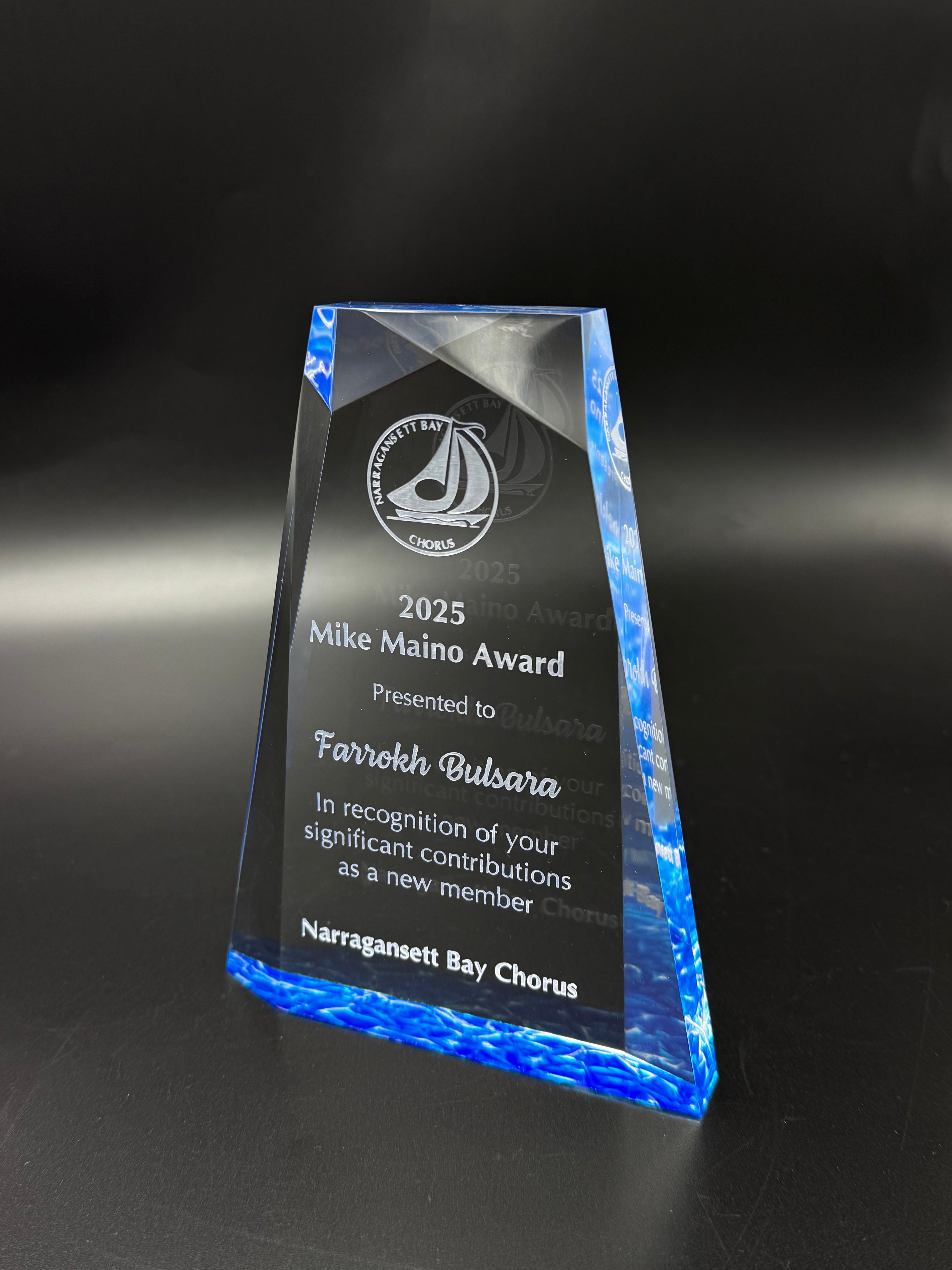 Acrylic award with engraved text on a dark background