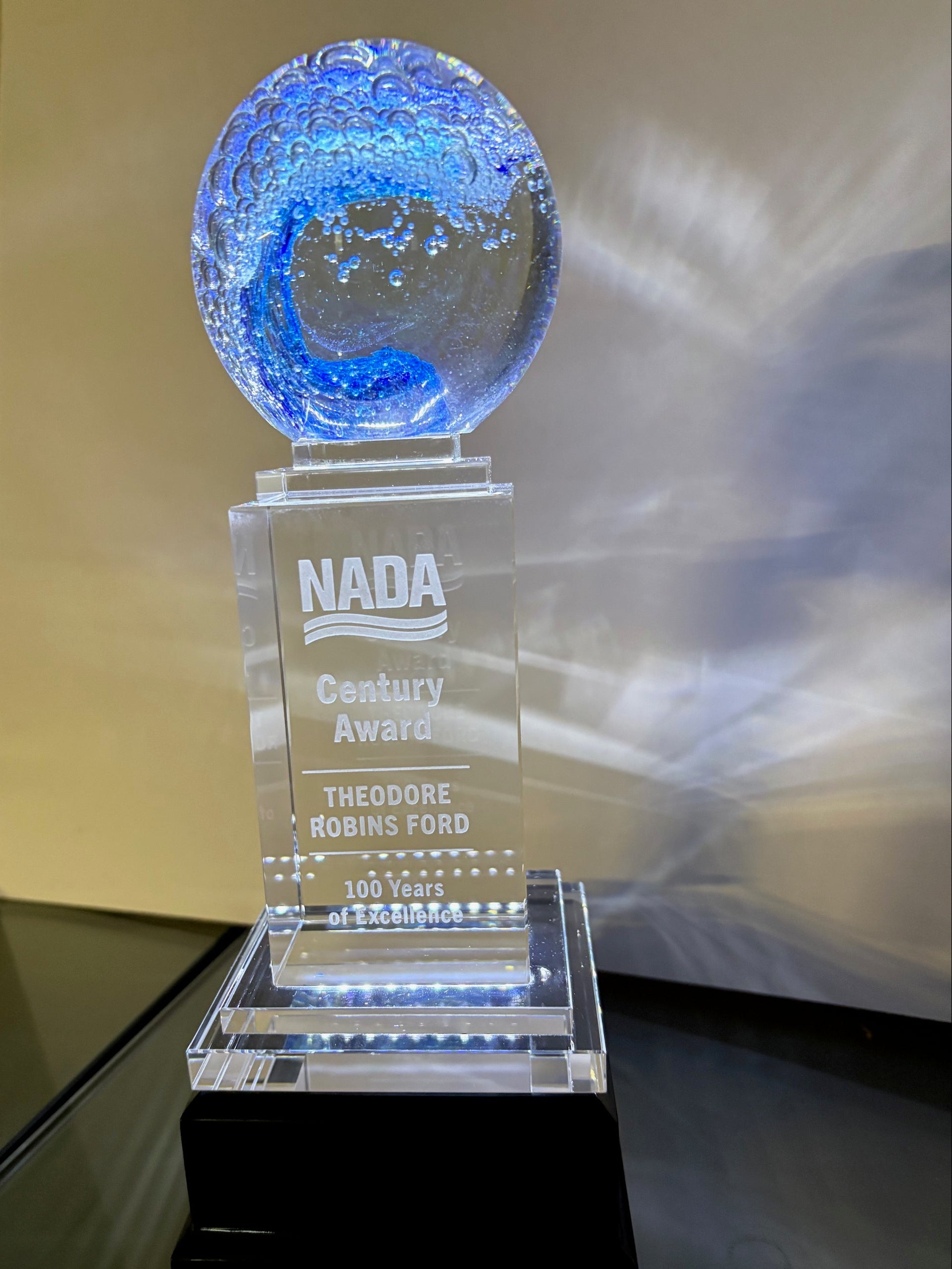 Clear award with blue sphere on a reflective surface