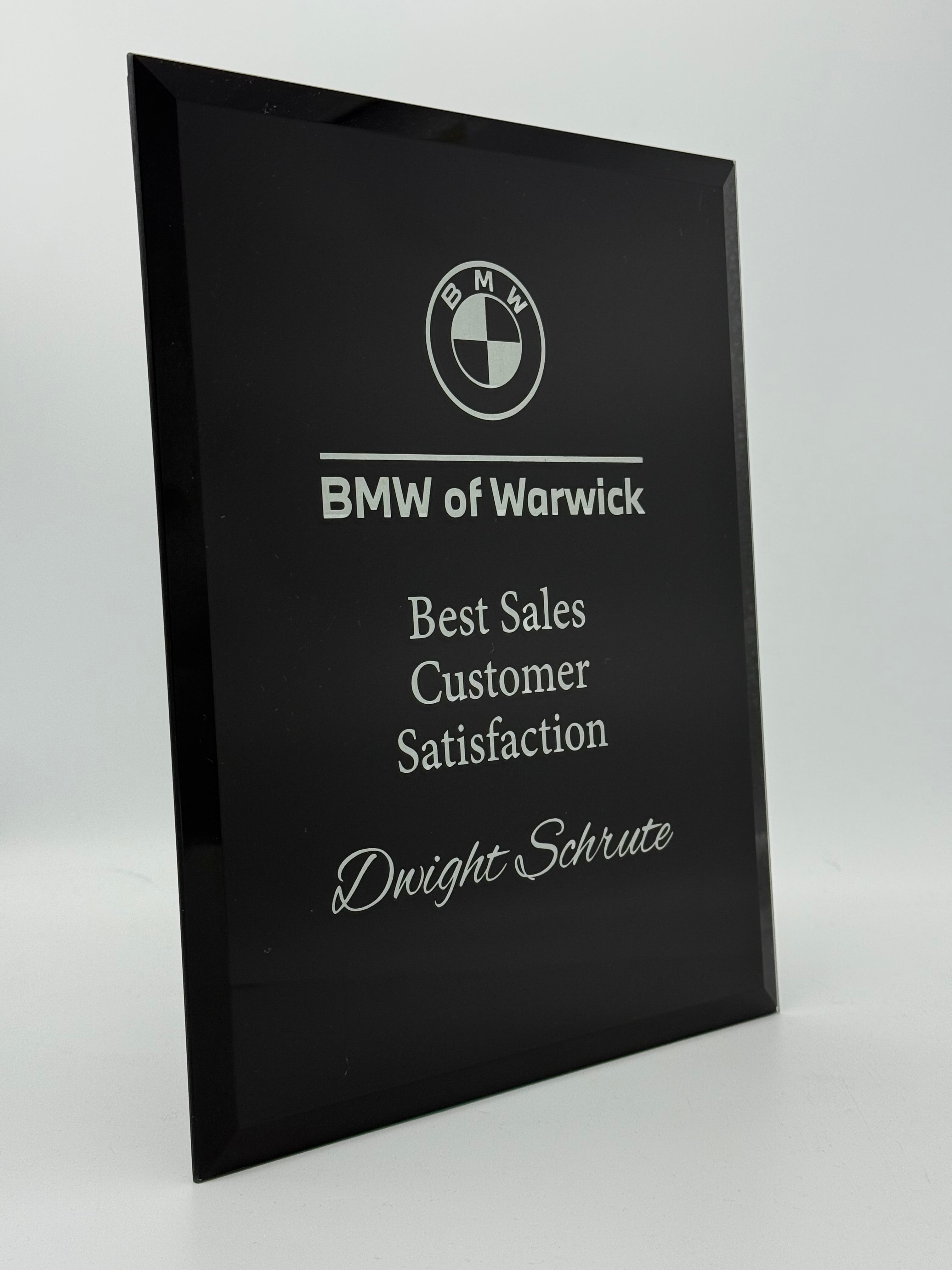 Black plaque with BMW logo and text on a black background