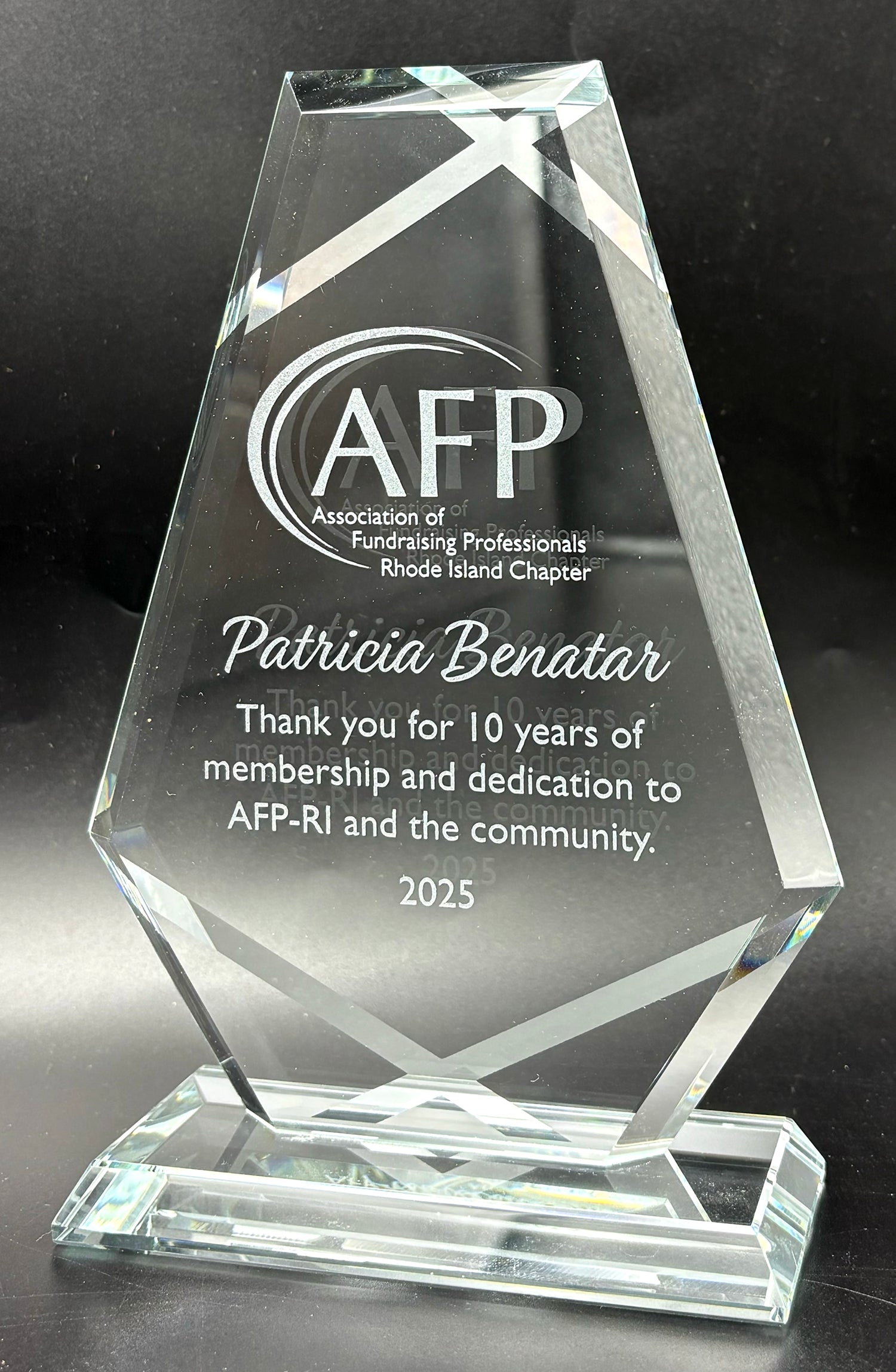 Crystal award with engraved text recognizing Patricia Benatar fand showing silver stips in the back.