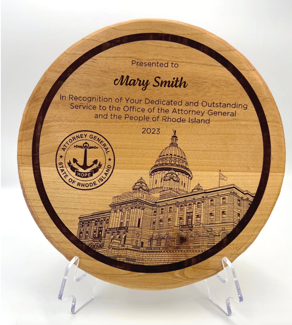 A circular wooden plaque with a engraved Rhode Island State House and text recognizing an individual's service.