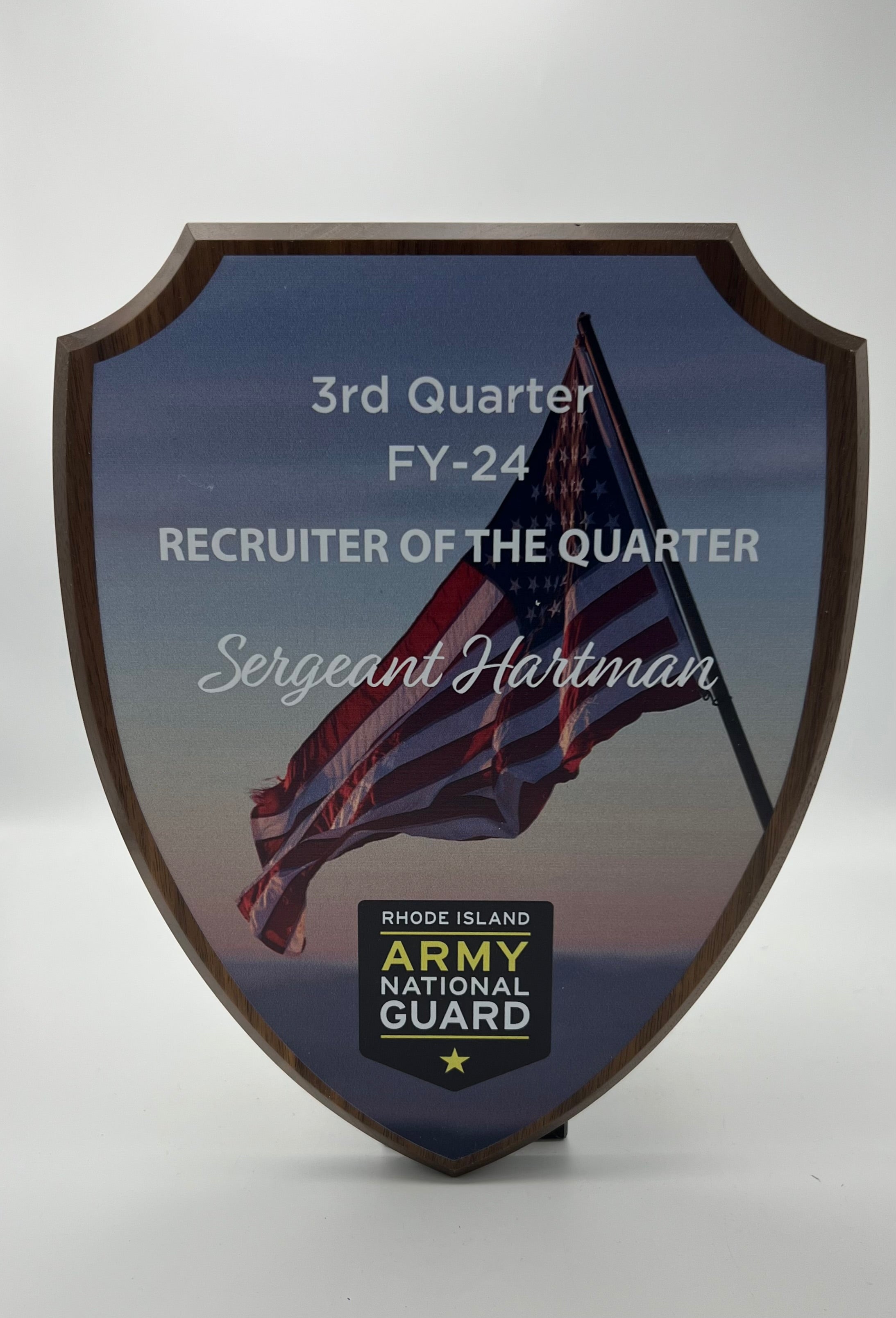 Wooden shield plaque with American flag in background